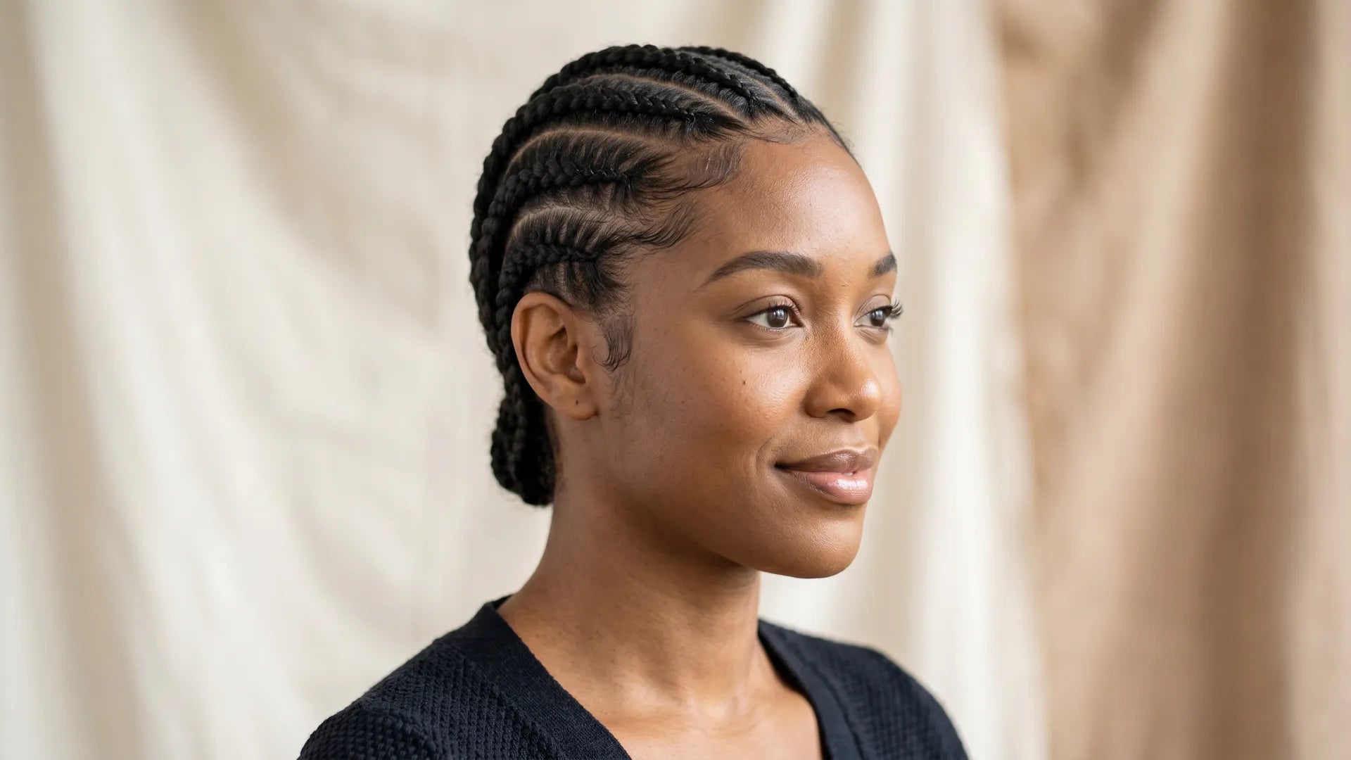 Profile view of a smiling woman showcasing neat, flat cornrows as the perfect braid pattern foundation for a Mimicing glueless wig install.