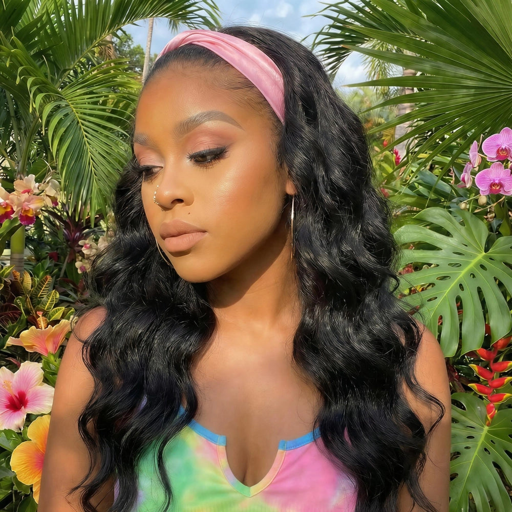 Mimicing Body Wave headband glueless virgin hair wig styled with a pink headband in a sunny tropical setting, showcasing a natural and effortless vacation look.